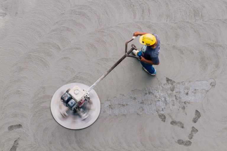 man smoothing out concrete with a machine