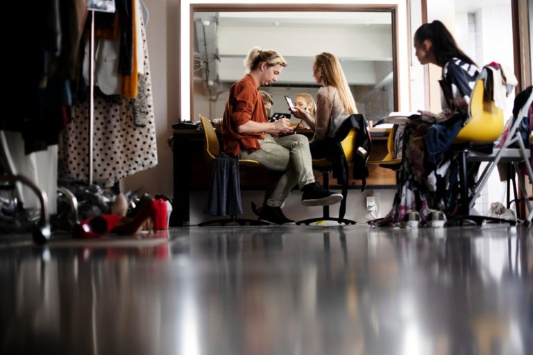 women applying makeup in the dressing room