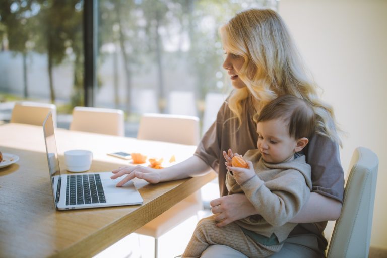 woman working while holding her baby