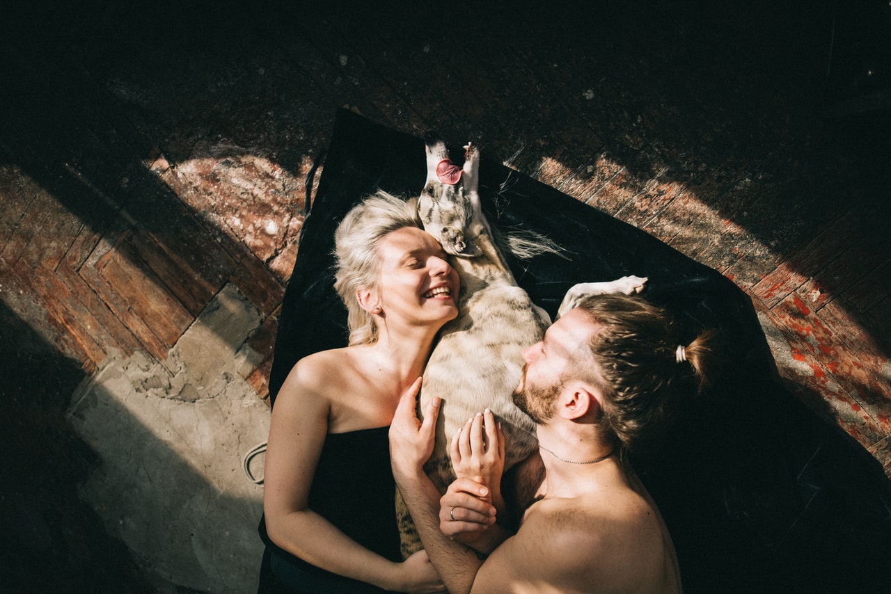 couple cuddling with their dog