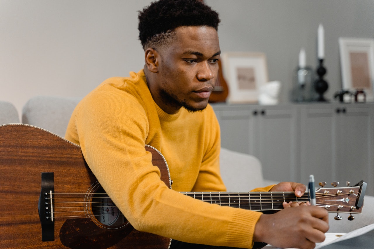 man learning to play guitar