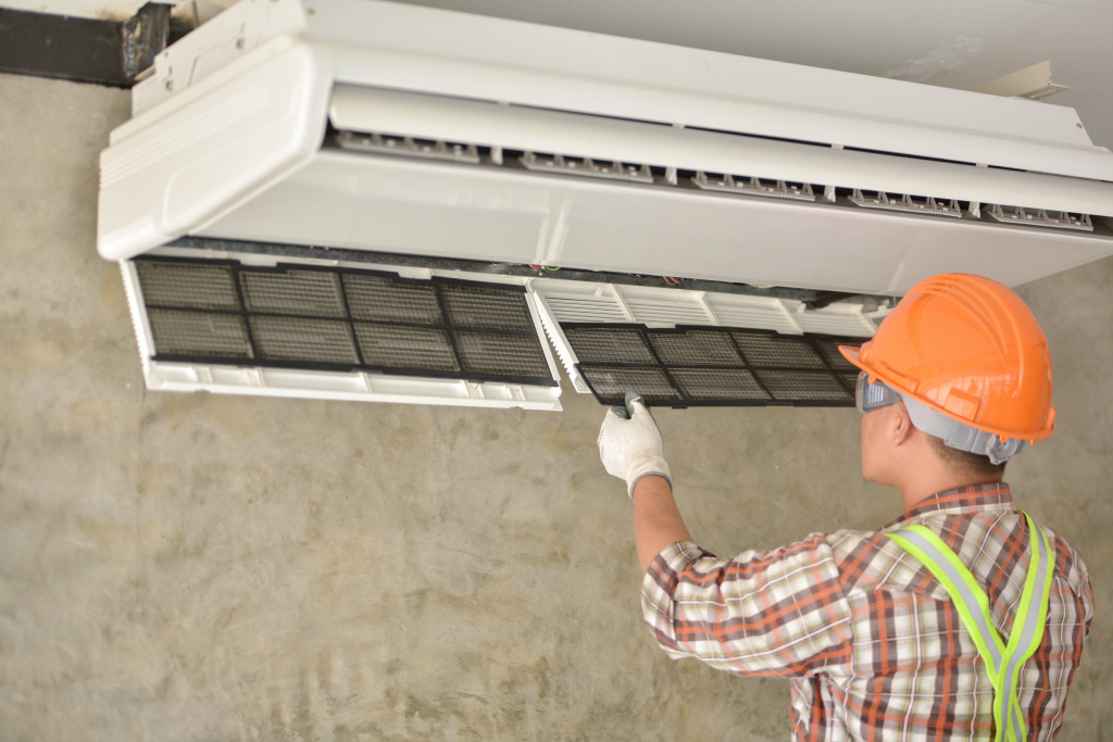 A male technician fixing a faulty air-conditioning unit