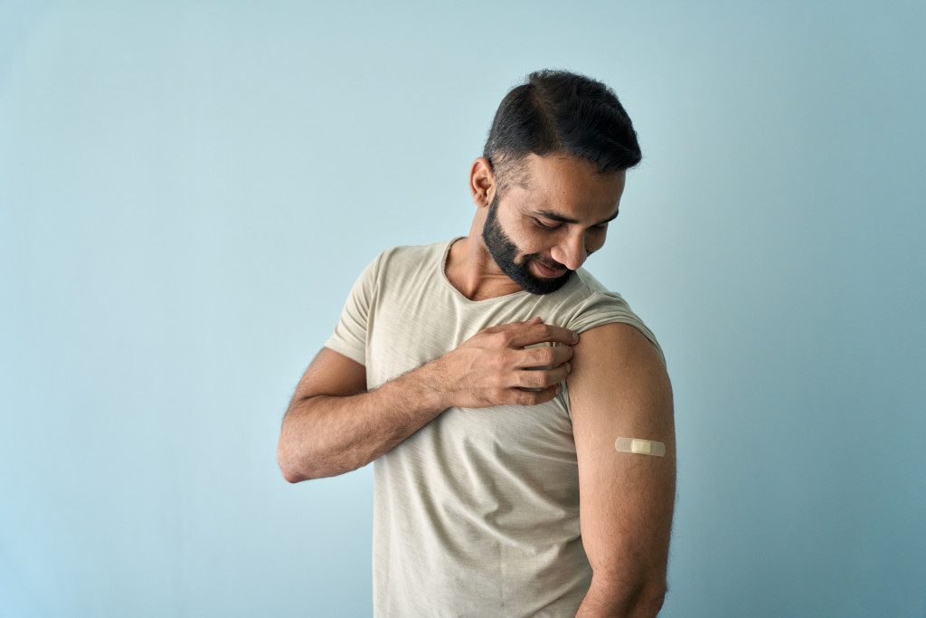 man showing bandage from vaccination 