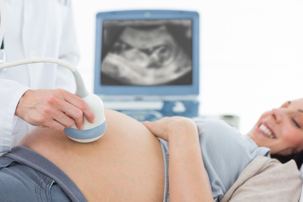 A doctor doing an ultrasound scan on a pregnant woman