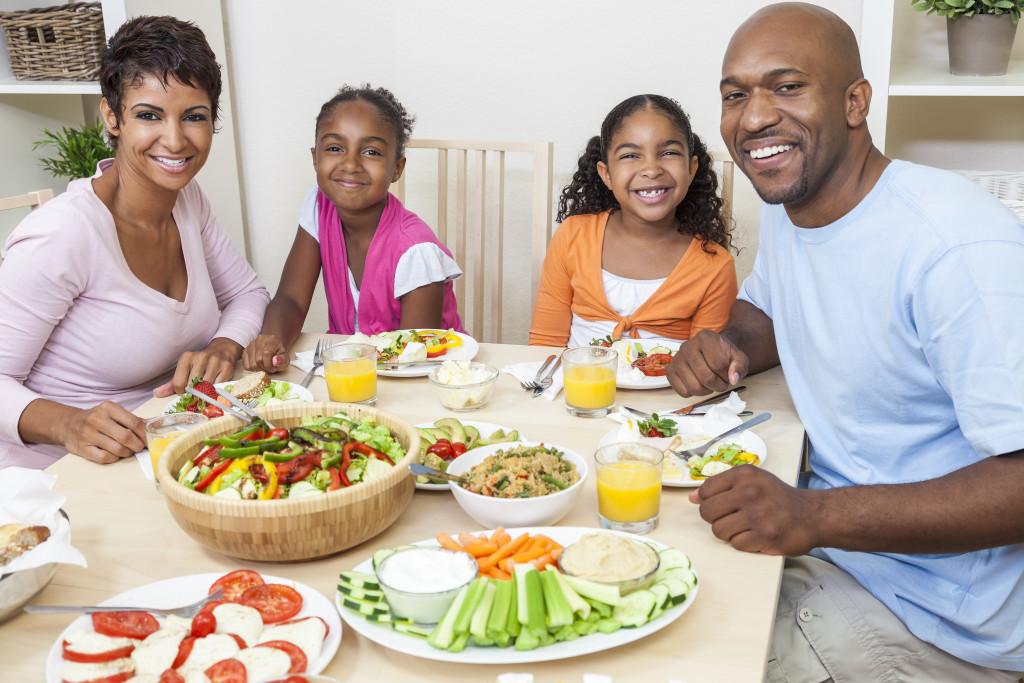 healthy happy family smiling while eating healthy food in the table