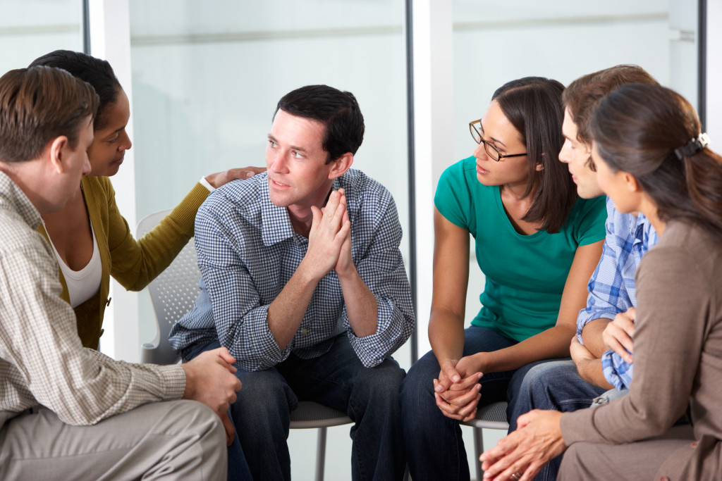 A group of people supportively talking to each other