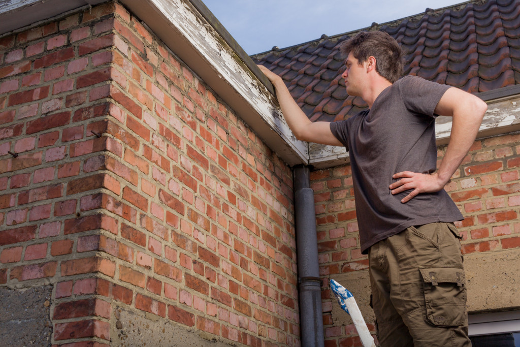 A man inspecting damage on the roof