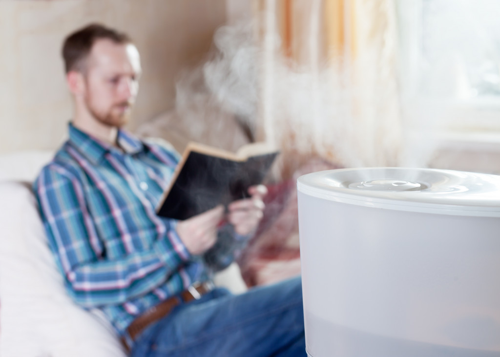 a man at home using an air purifier