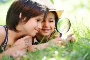 2 kids learning using magnifying glass