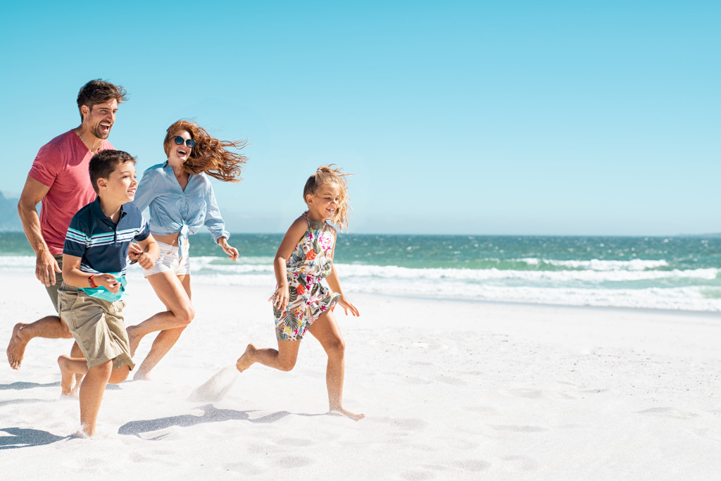 A young family running on the beach