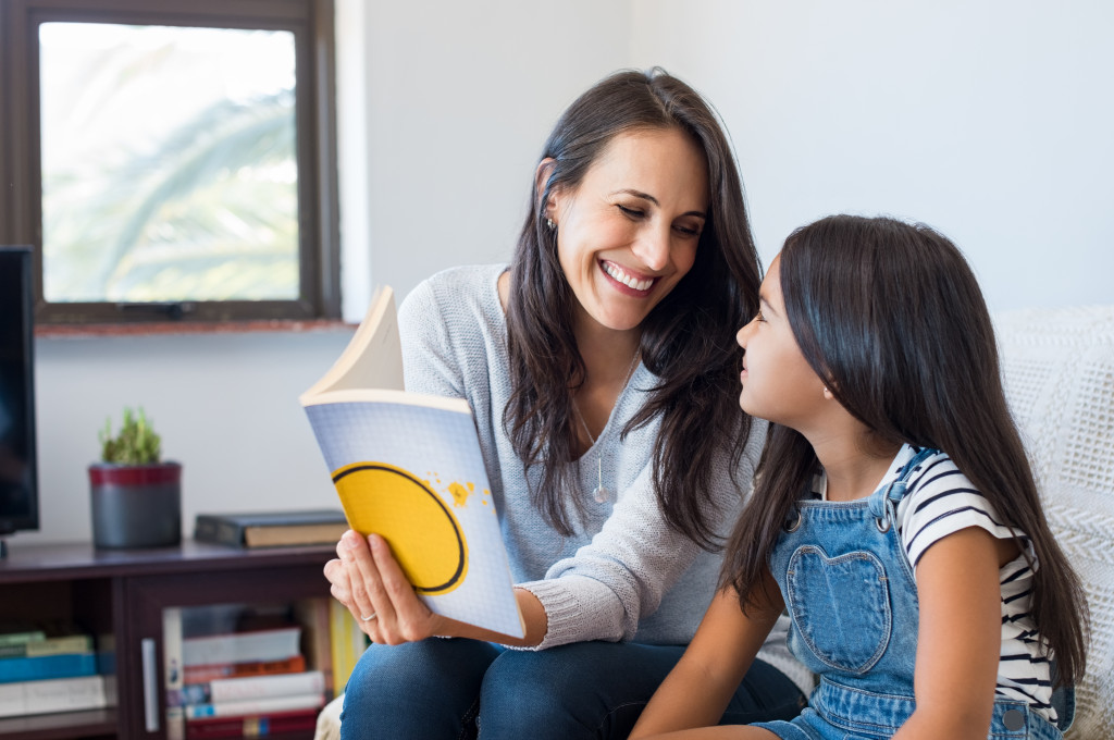 happy mom reading a book with her daughter