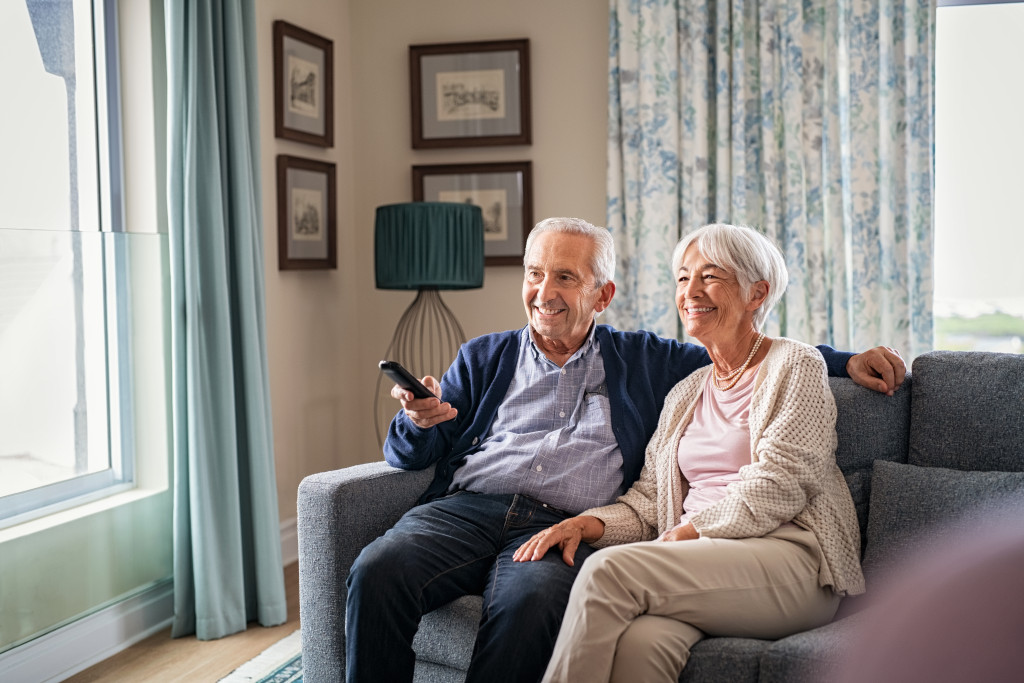 a senior couple watching tv at home