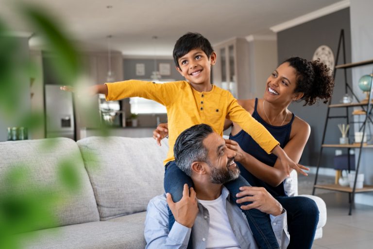 Playful little boy enjoying spending time with parents at home