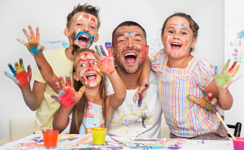 happy father with children playing with paint