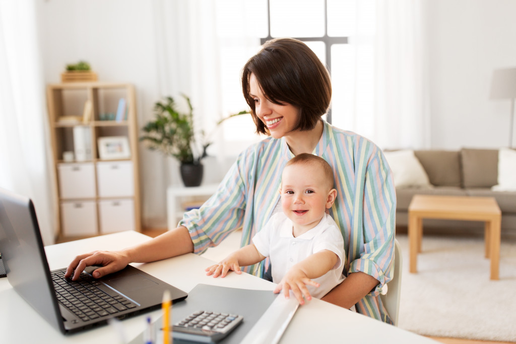 smiling working mom while carrying her baby