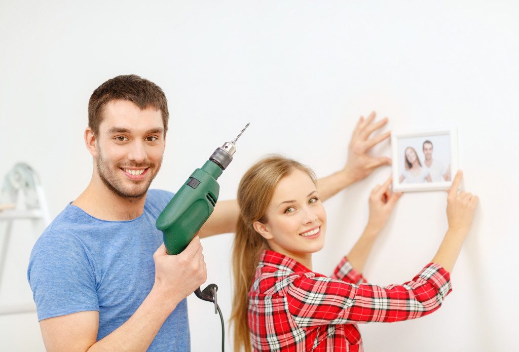 couple hanging a frame of photo on the wall