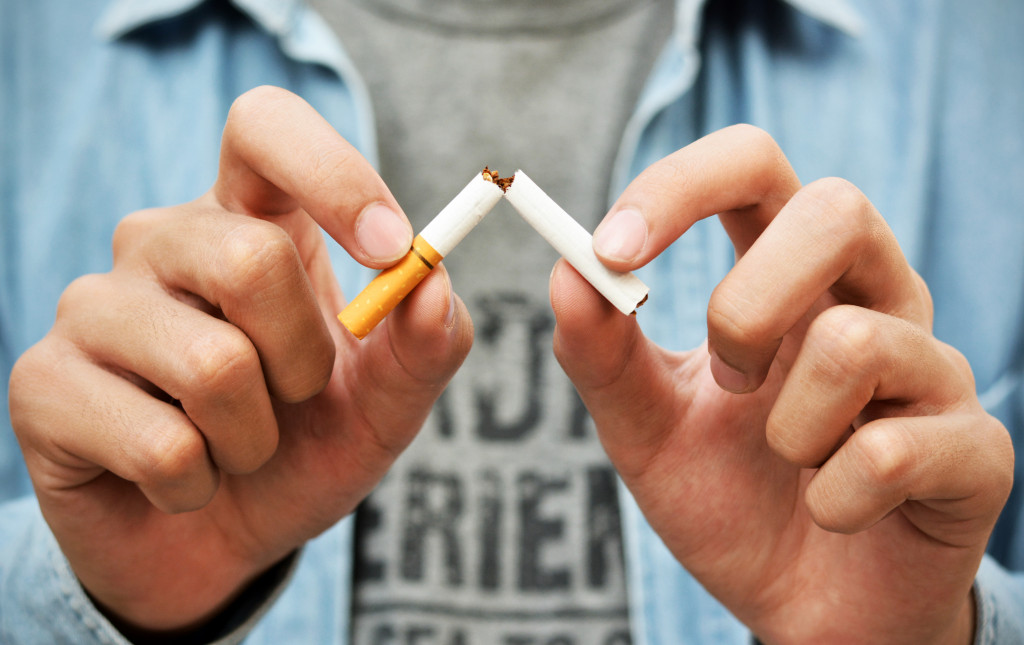 A man breaking a cigarette in half