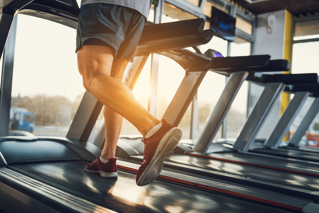 man running on treadmill in gym