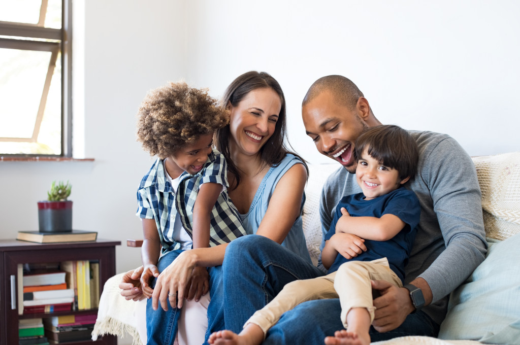 happy multiethnic family sitting in sofa