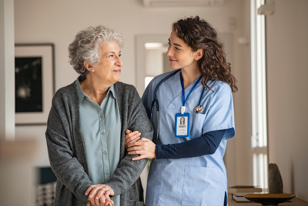 A caregiver assisting a senior woman walk