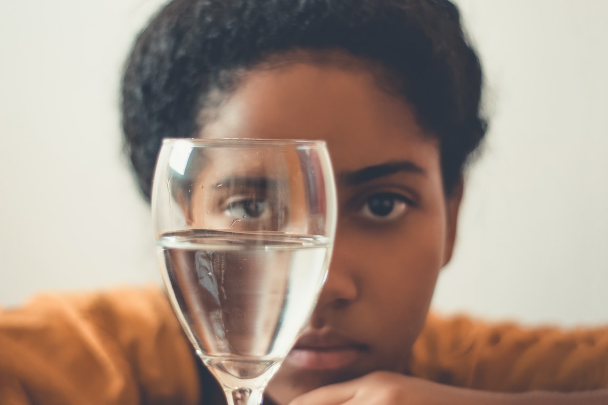 Woman Staring on Glass Bottle