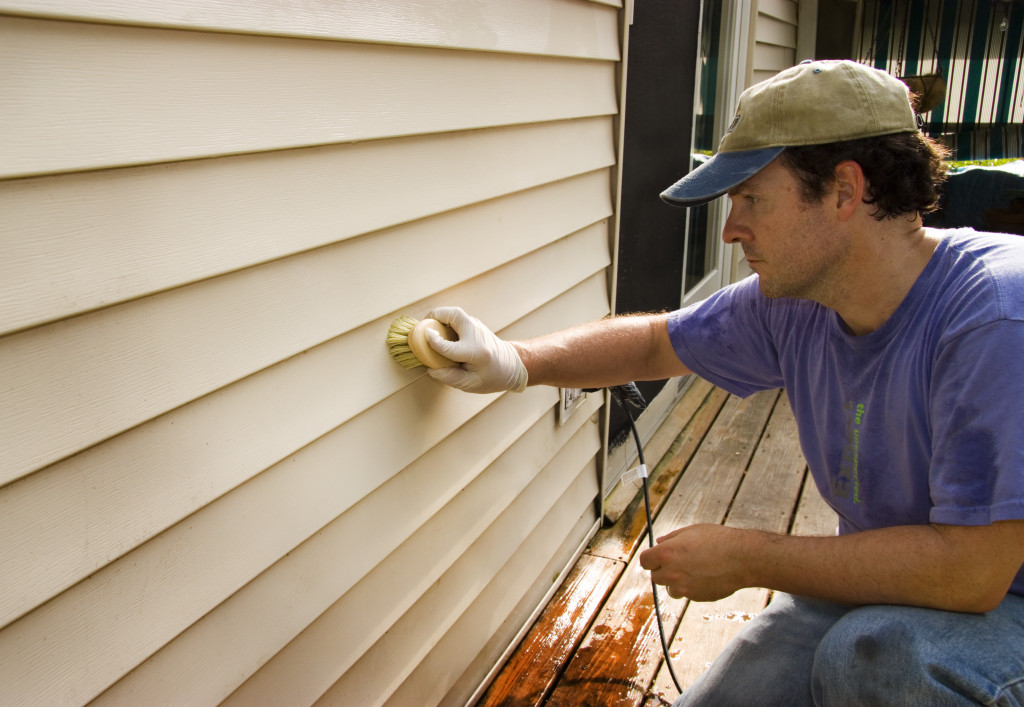 man cleaning the home siding