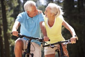 Senior couple riding bicycles at a park.