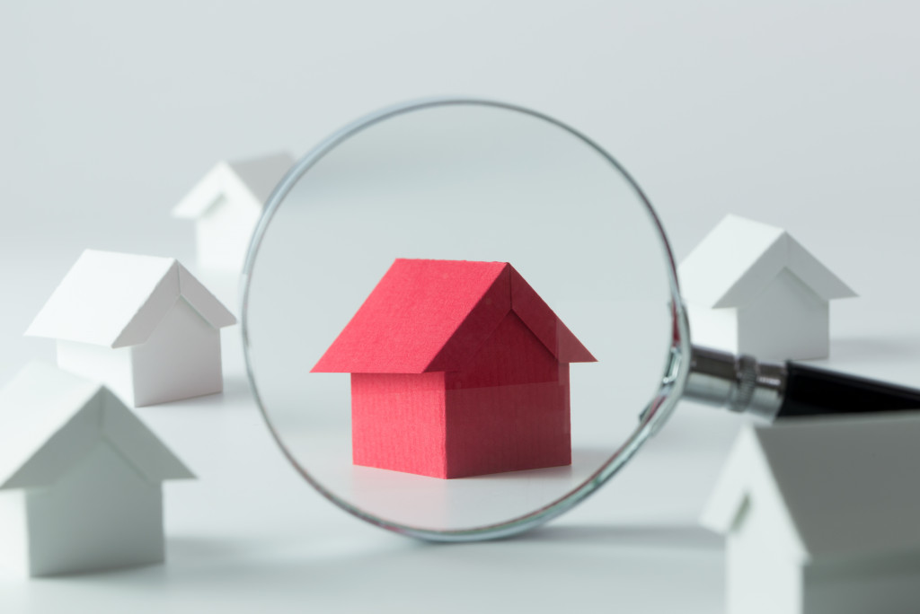 red model house under magnifying glass