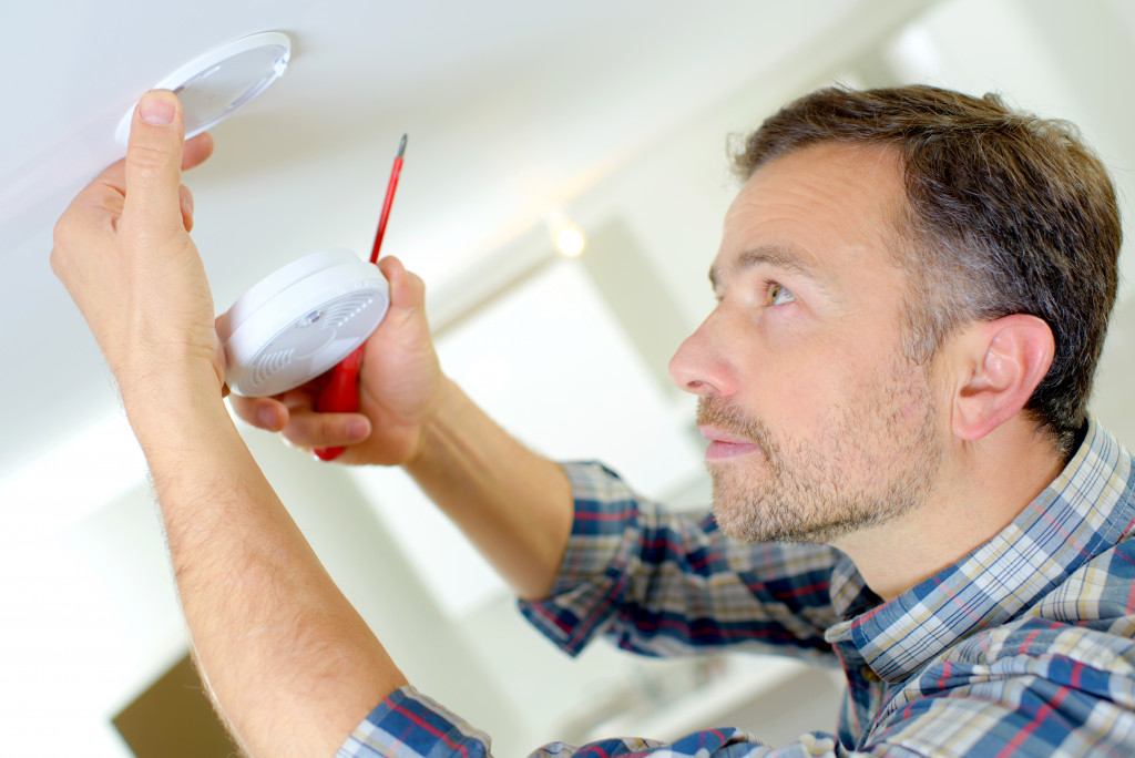 man installing smoke detector