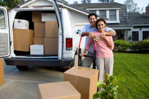 couple moving abroad with boxes of stuff being placed inside a moving van