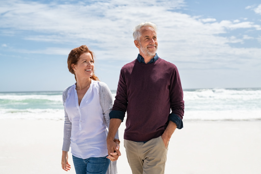 A senior couple out on a beach stroll