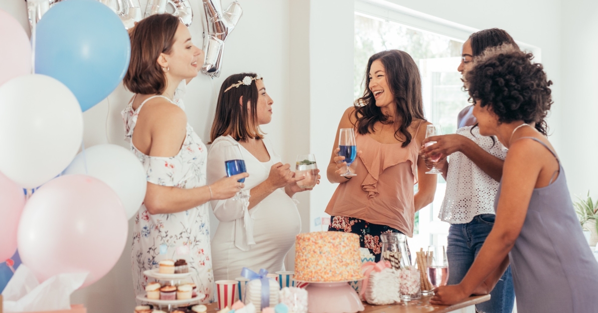 Pregnant woman celebrating baby shower with female friends at home