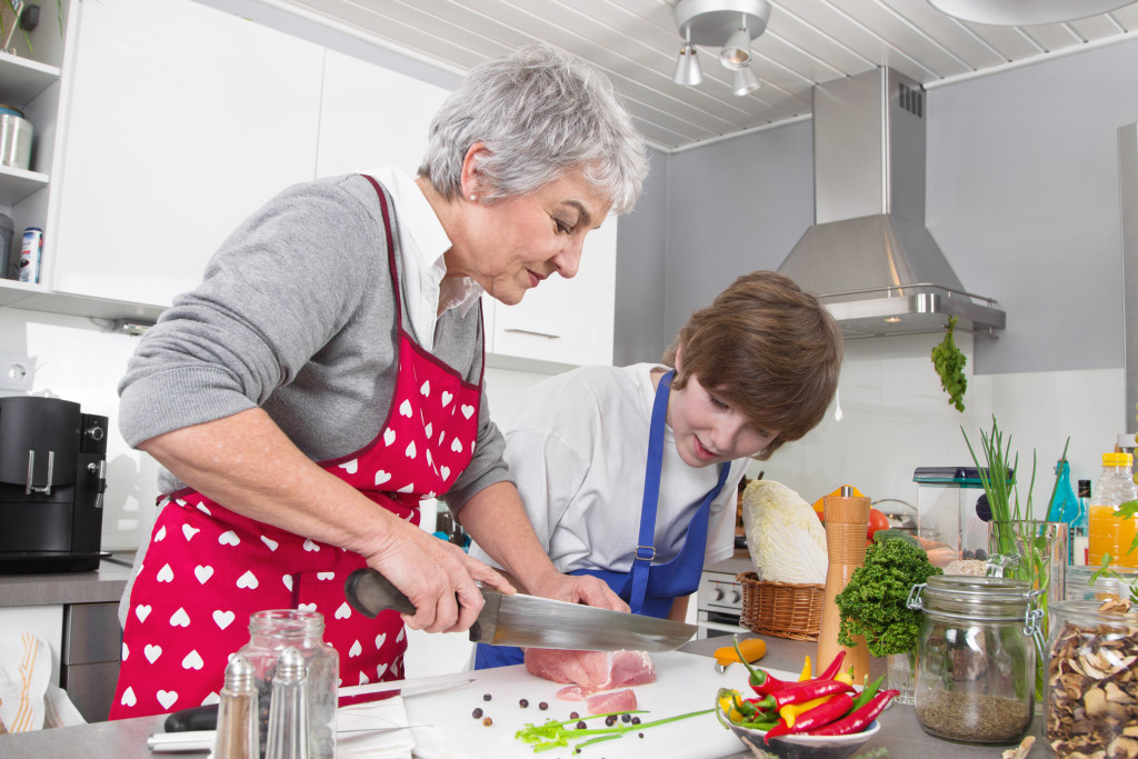 Grandmother and grandson preparing a meal at home.