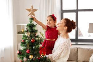 mother and daughter decorating Christmas tree at home