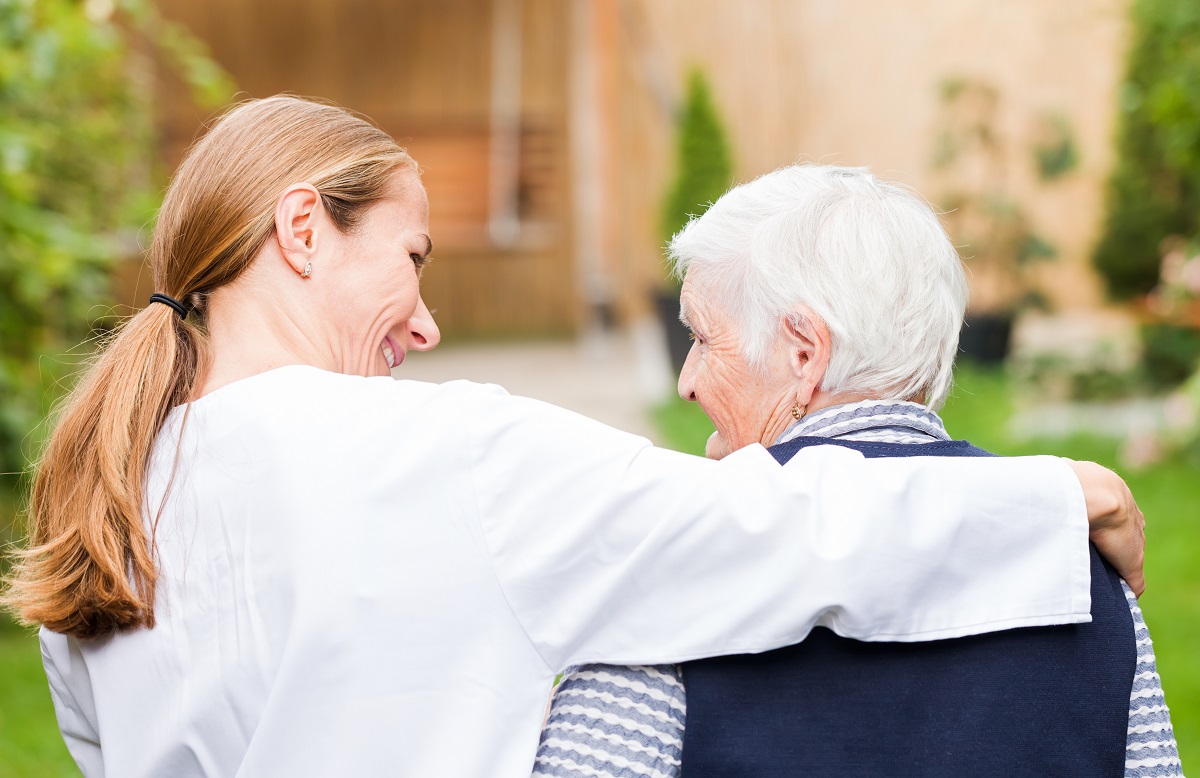 older woman being talked to in hospice